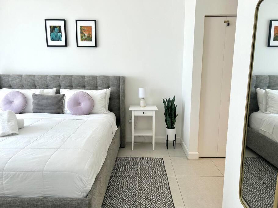 a bedroom with a large white bed with pink pillows at Comfortable Studio suites in downtown Doral in Miami