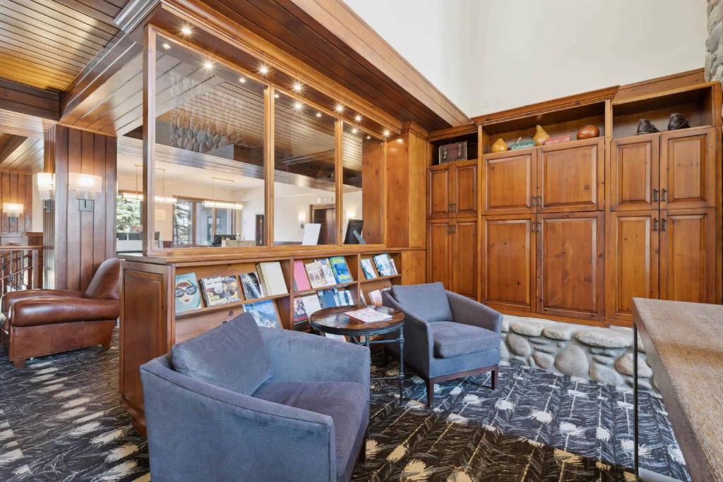 a living room with wooden cabinets and chairs and a table at McCoy Peak 305 by East West Hospitality in Beaver Creek