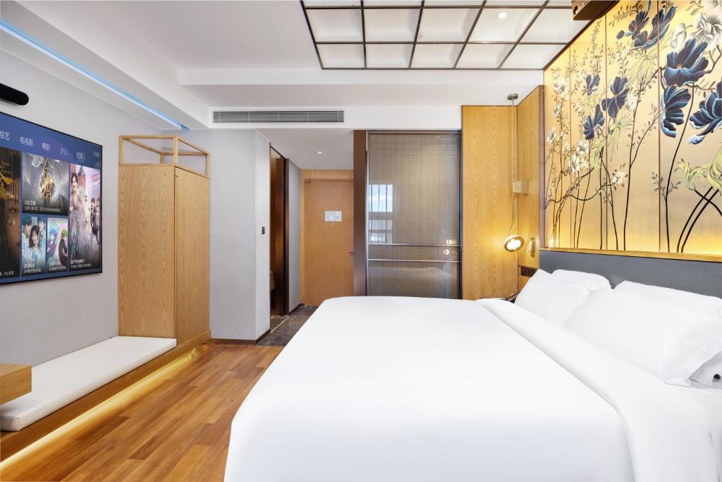 Postel nebo postele na pokoji v ubytování Jingli Hotel - Beijing New National Exhibition Capital Airport