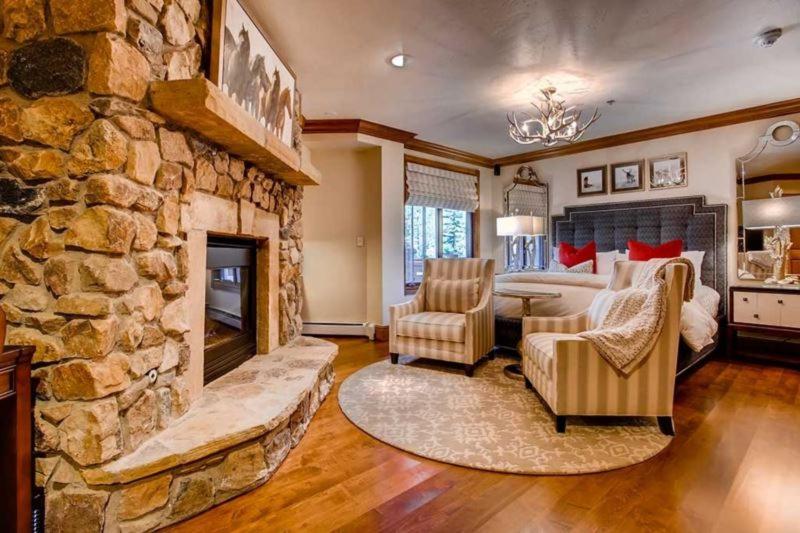 a large room with a stone fireplace and a bed at McCoy Peak 201 by East West Hospitality in Beaver Creek