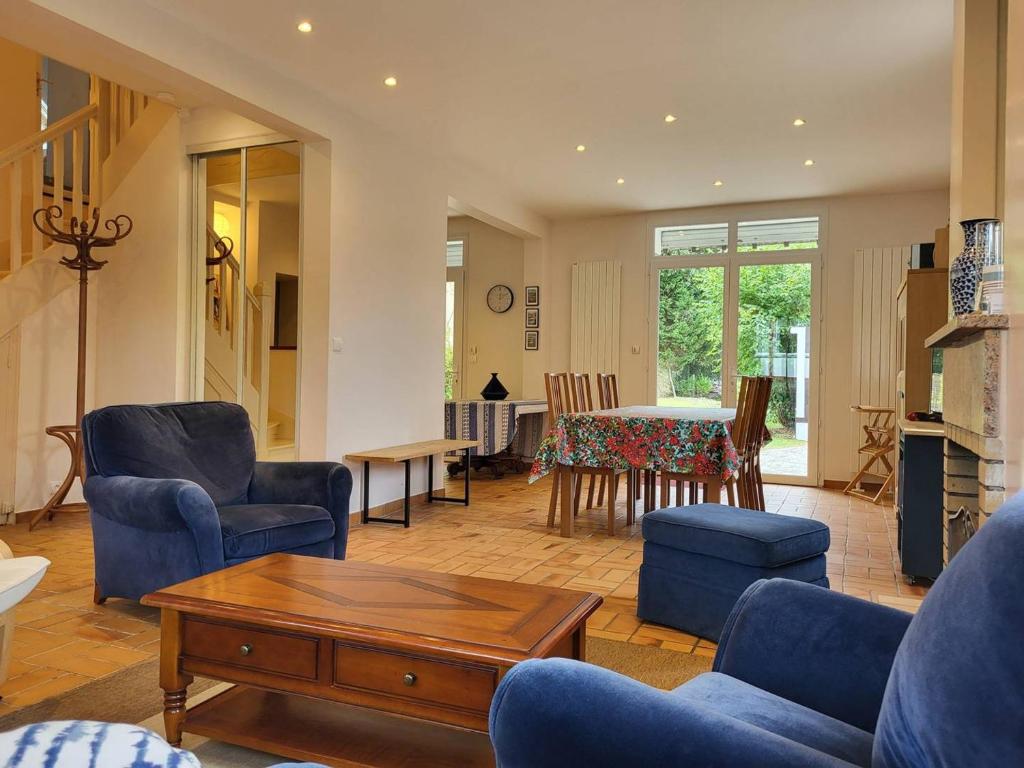 un salon avec des chaises bleues et une table dans l'établissement Maison de famille avec jardin clos et terrasse proche de la plage - FR-1-788-31, à Merville-Franceville-Plage