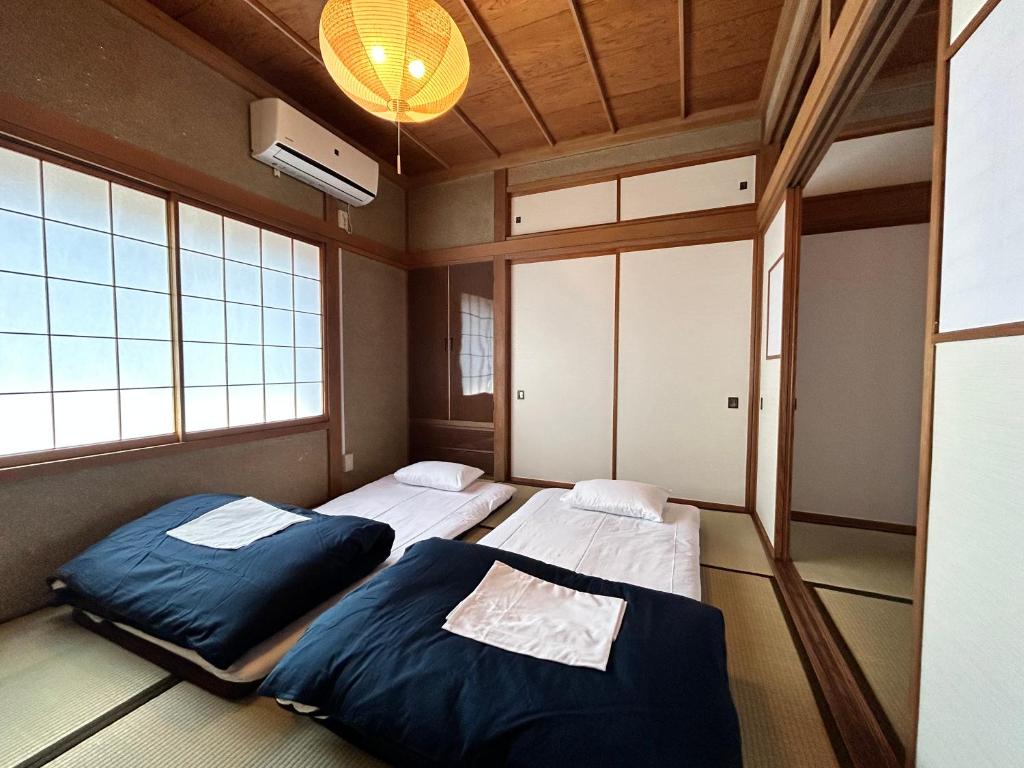 two beds in a room with two windows at tot-an 14mins from Toyama station #HH7 in Toyama Station