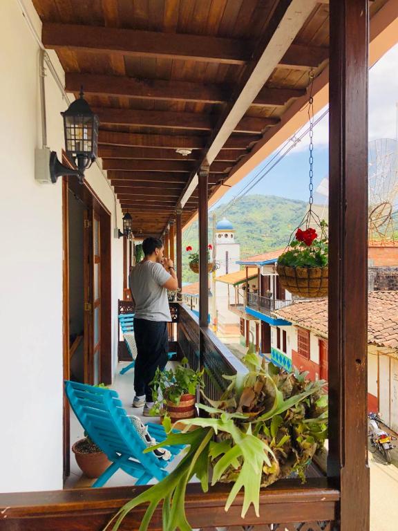 a man standing on the balcony of a house at HOTEL PLENITUD JARDÍN - Transporte, Tours y Más in Jardin