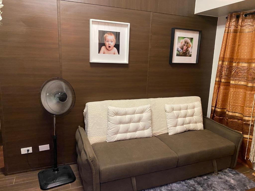 a living room with a couch and a fan at Makati Air Luxury Package - Laugh Sleep Brunch Surf 300 mbps Fast in Manila