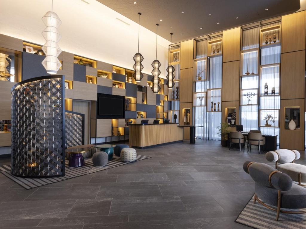 a lobby of a hotel with a reception desk and chairs at Novotel Nara in Nara