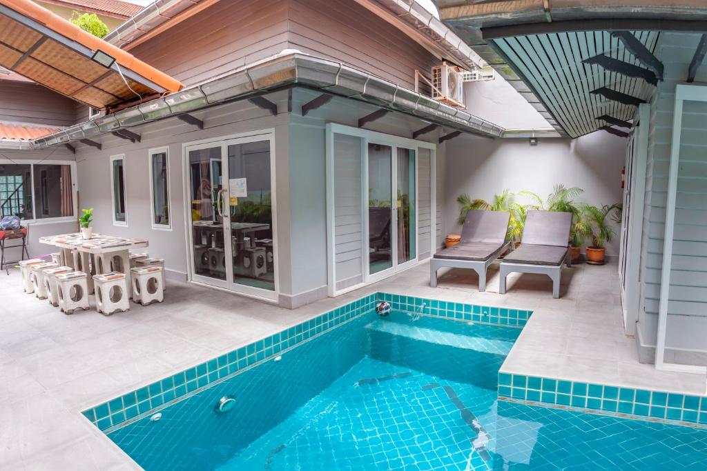 an outdoor swimming pool with a patio and a house at ROMANTIC Pool Villa in Pattaya South