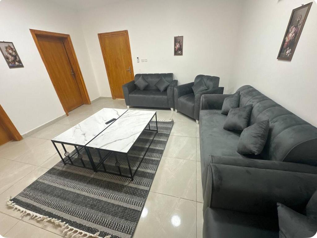 a living room with a couch and a coffee table at نجوم السعد 8 in Al Masfalah