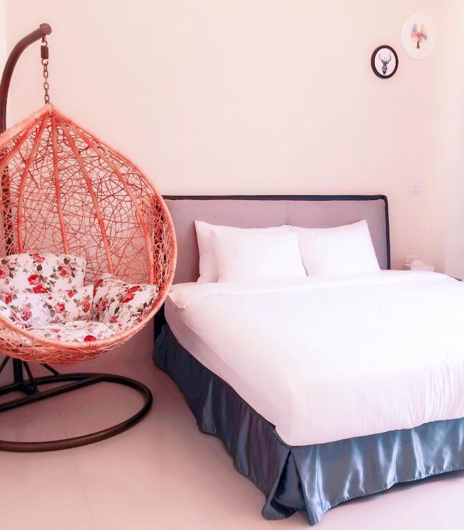 una camera con letto e sedia sospesa di Happy Fat B&B 寵物友善 a Città di Taitung