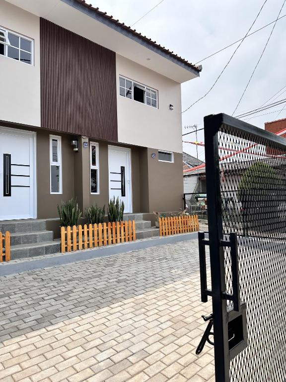 a house with a fence in front of it at Omame House Ciamis in Ciamis