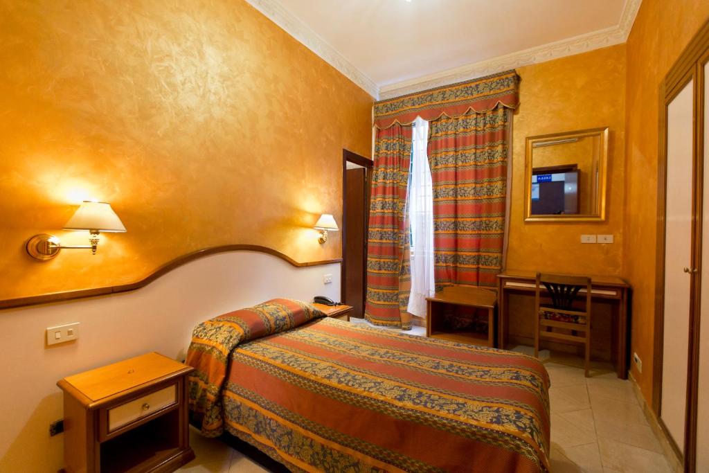 une chambre d'hôtel avec un lit et une table dans l'établissement Hotel Lella, à Rome