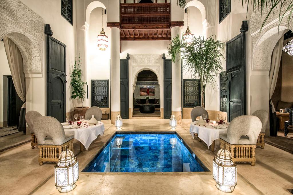 a restaurant with a pool in the middle of a room at Dar Assiya in Marrakesh