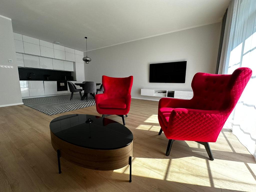 a living room with two red chairs and a table at Rezidencia OPERA - Villa Bizet in Turčianske Teplice