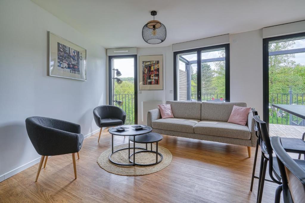 un salon avec un canapé, des chaises et une table dans l'établissement Appartement cosy lumieux- cadre verdoyant, à Gif-sur-Yvette