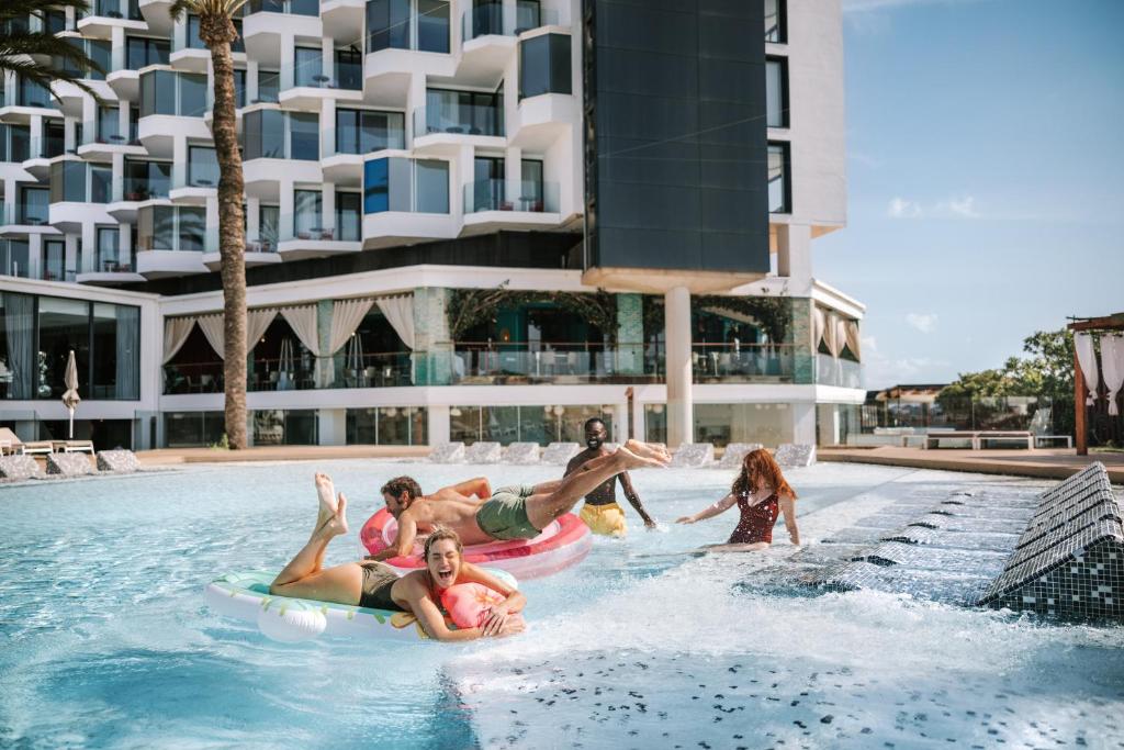 a group of people playing in the pool at a resort at Hard Rock Hotel Ibiza in Playa d'en Bossa