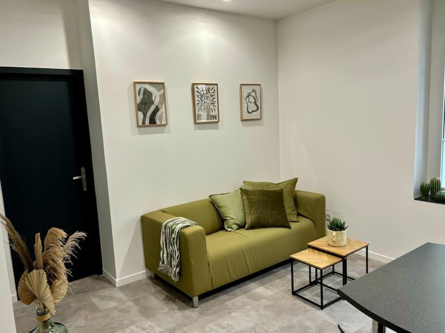 un salon avec un canapé vert et une table dans l'établissement L'Olivier - Calme, Chaleureux, proche transports, à Lyon