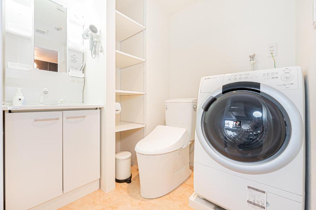 東京にあるNew Cozy APT Located on the Japanese Local shopping streetの白いバスルーム(洗濯機、乾燥機付)