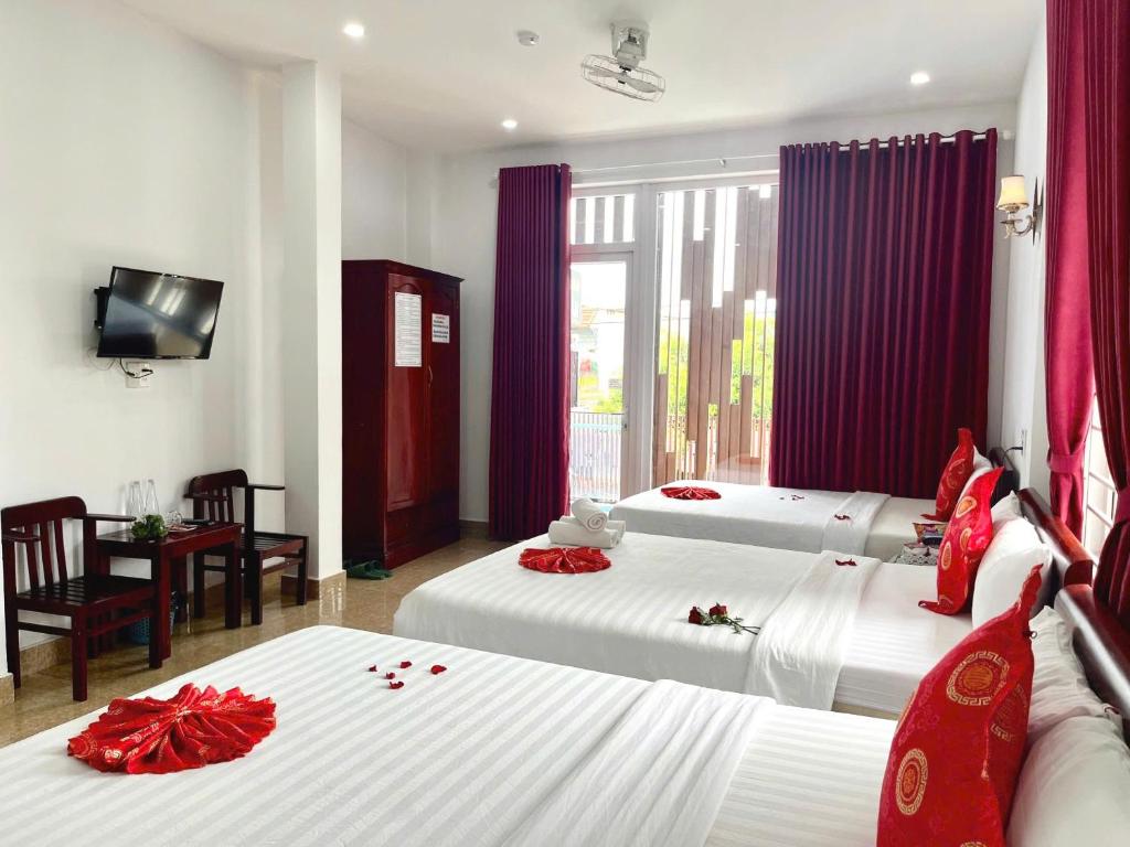 a bedroom with two beds with red flowers on them at OPA HOTEL HUE in Hue