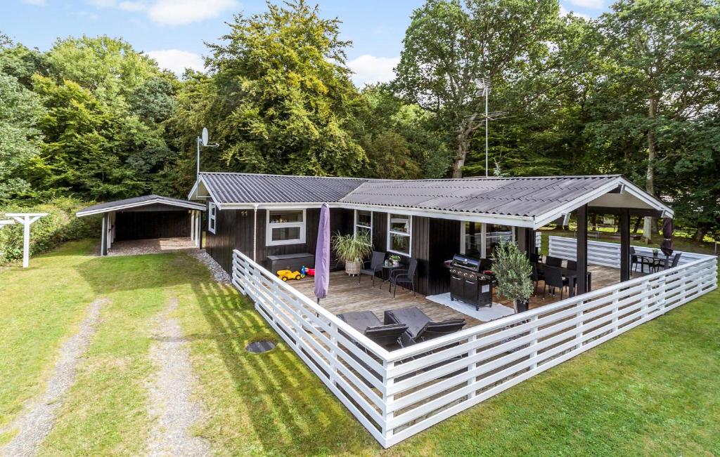 a small house with a porch and a deck at Holiday Home Bøsholmstien Glesborg Denm in Fjellerup Strand