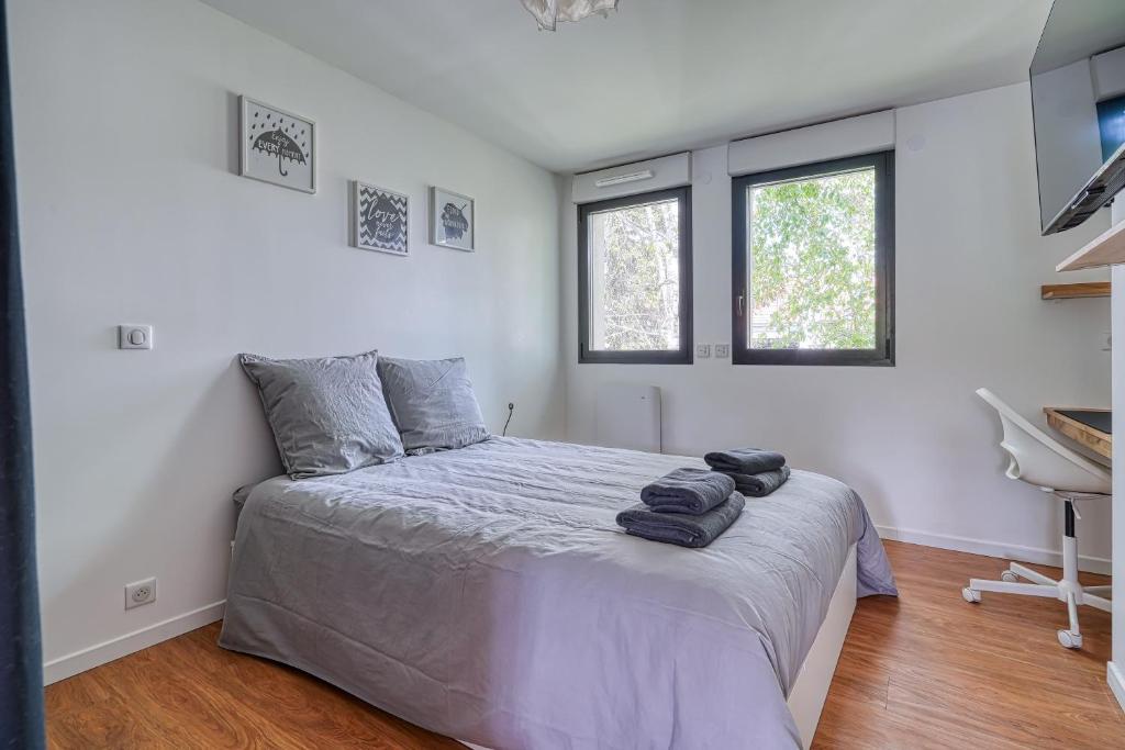 une chambre avec un lit avec des serviettes dessus dans l'établissement Chambre cosy - cadre verdoyant - proche Saclay, à Gif-sur-Yvette