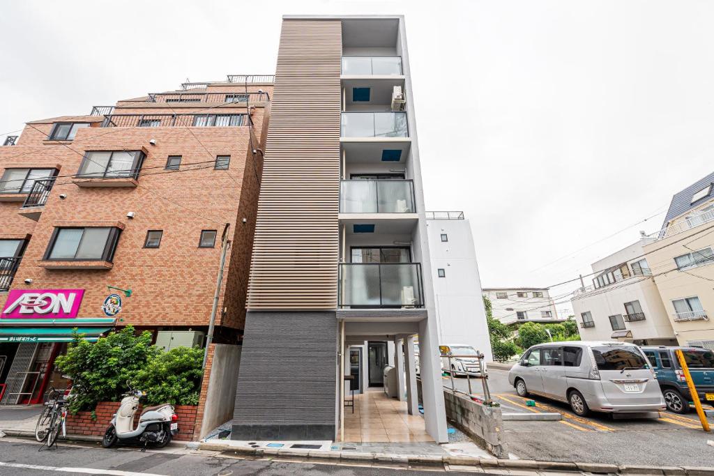 東京にあるNew Cozy APT Located on the Japanese Local shopping streetの前方に停車したスクーターのある通りの建物
