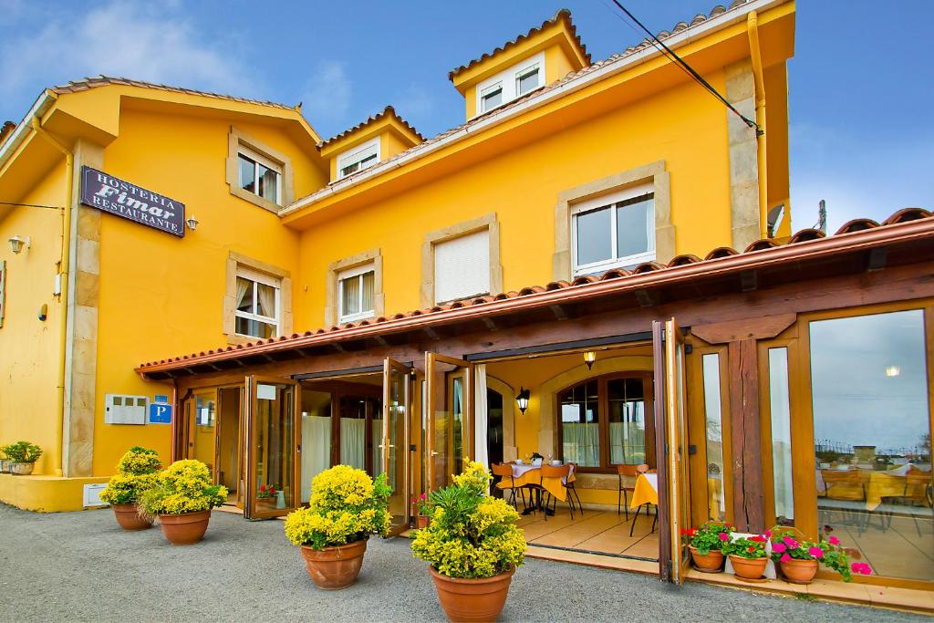 un edificio amarillo con macetas delante de él en Hostería Fimar, en Ubiarco