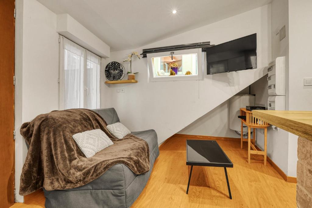 - un salon avec un canapé et un escalier dans l'établissement Appartement Cosy - Terrasse - Proche Métro, à Toulouse