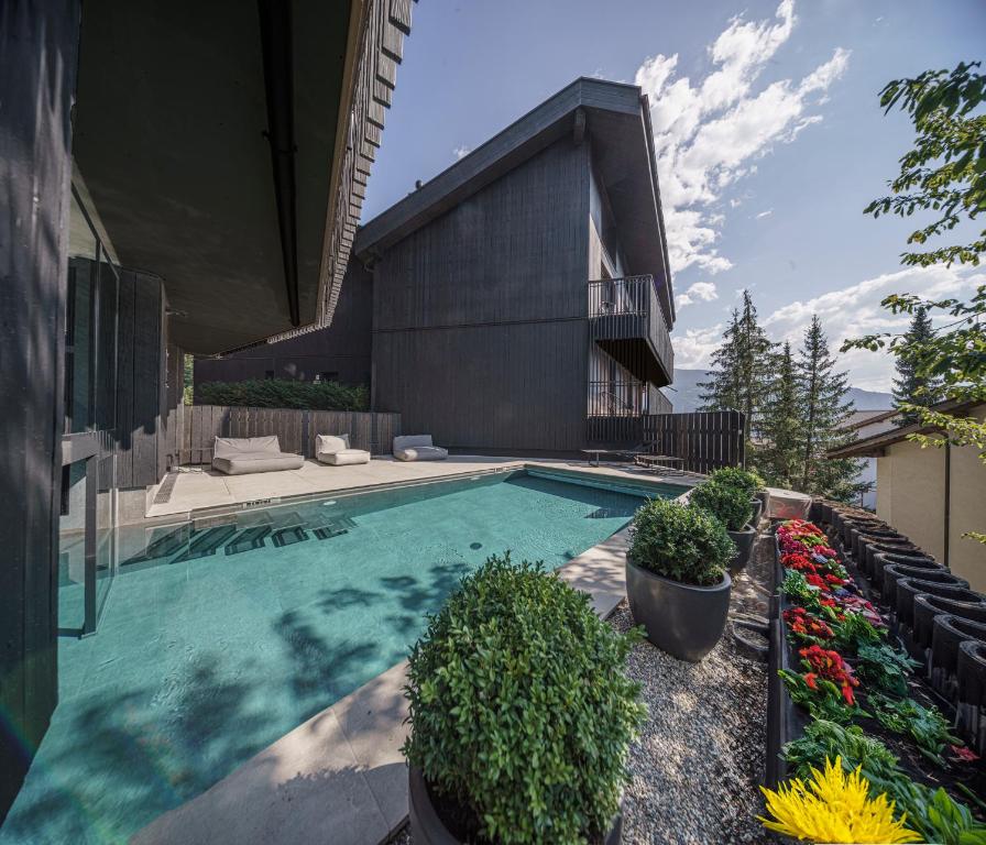 a swimming pool in the backyard of a house at Black Summit Boutique Resort Laax in Laax