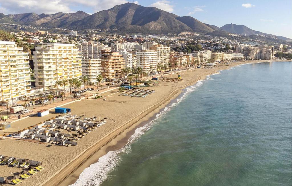 an aerial view of a beach with beach chairs and buildings at Stunning Apartment In Fuengirola in Fuengirola