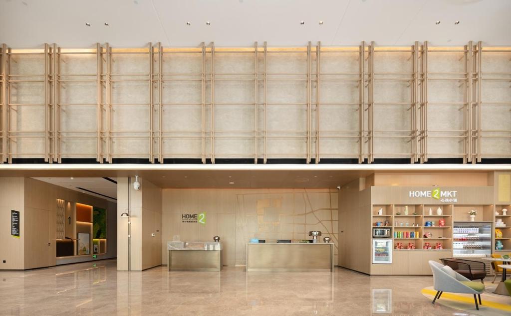 a lobby of a shopping mall with a large glass wall at Home2 by Suite Liaocheng Dongchang in Liaocheng