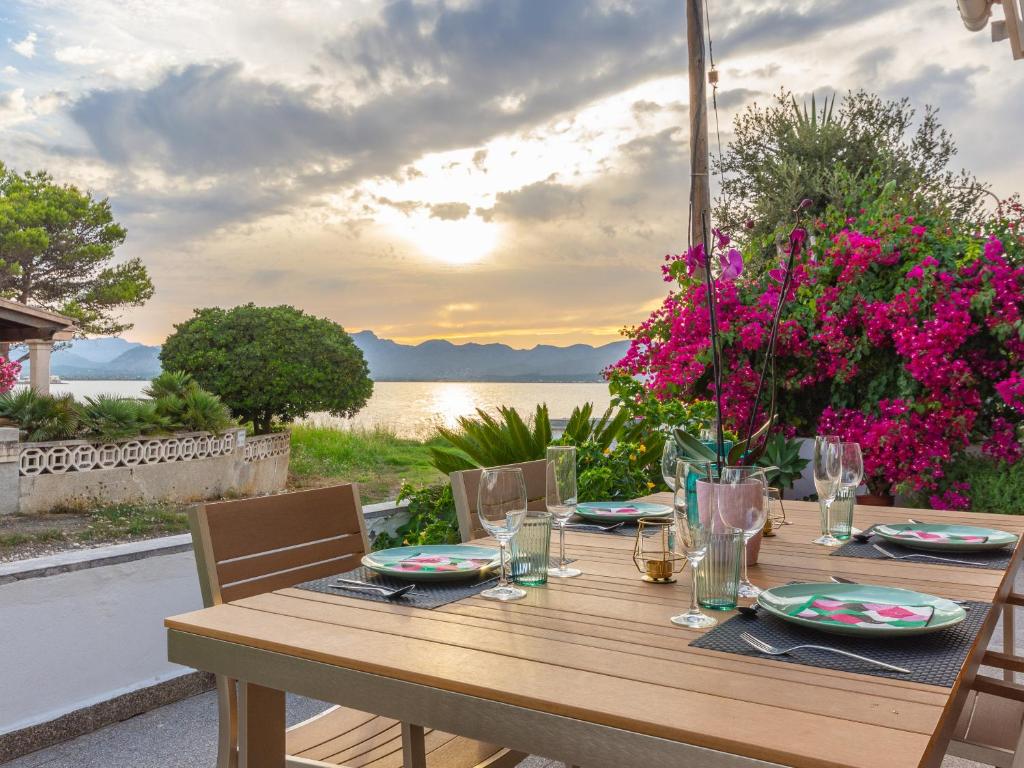 a wooden table with chairs and a table with flowers at 274 Villa Manresa ETV 4301 by Mallorca Charme in Alcudia