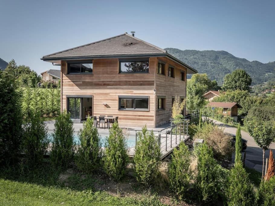 une maison en bois avec une piscine en face de celle-ci dans l'établissement Venez Chez Vous Villa Nature, à Alex