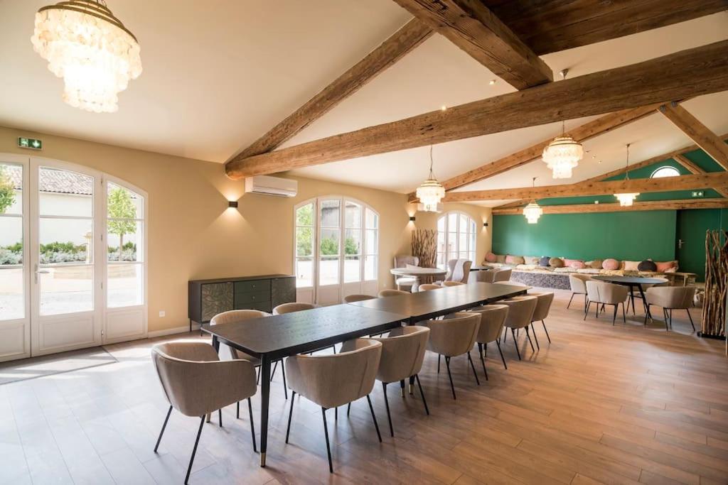 une grande salle à manger avec une longue table et des chaises dans l'établissement Gîte de Groupe campagne 15 personnes avec piscine, à Montagnac