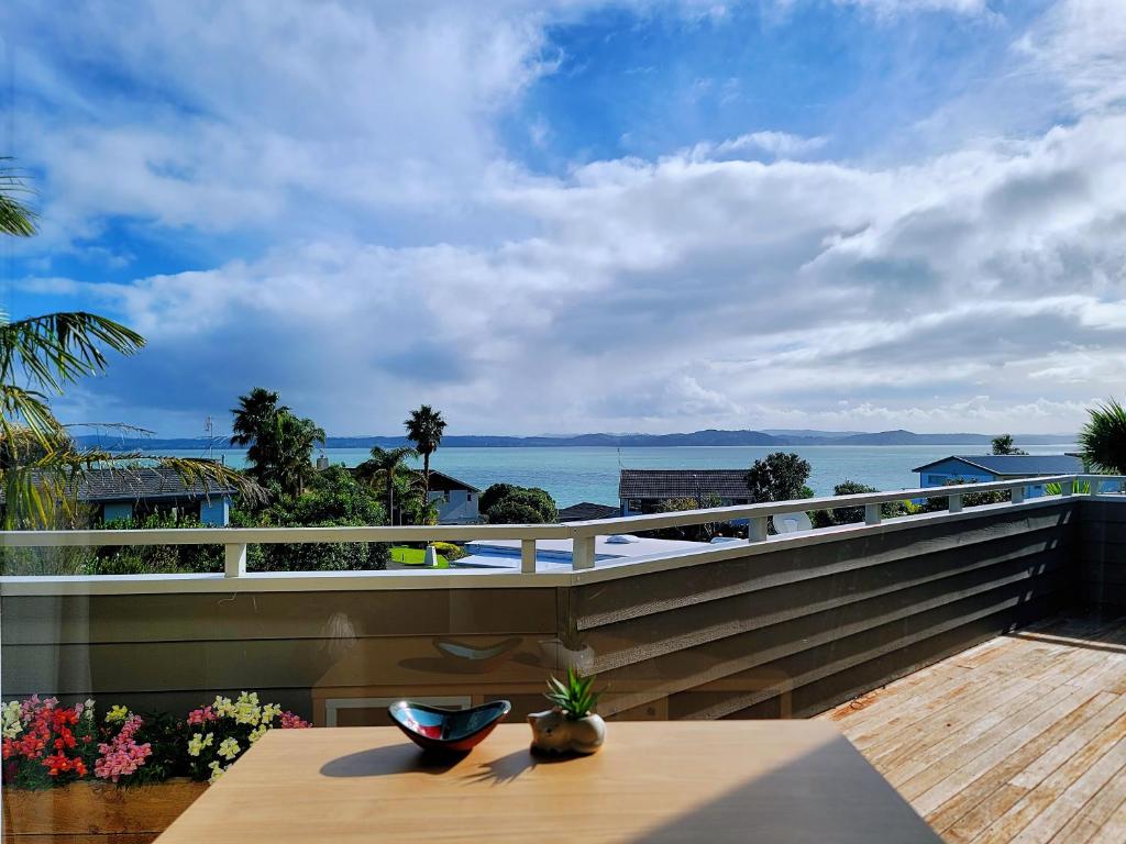 a balcony with a table and a view of the ocean at Sea view 5 bedroom holiday house in Whangaparaoa