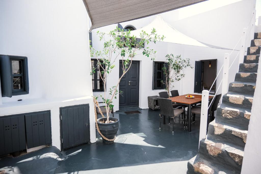 un patio con una mesa y un árbol en una olla en 1906 Cave Villa, en Pirgos