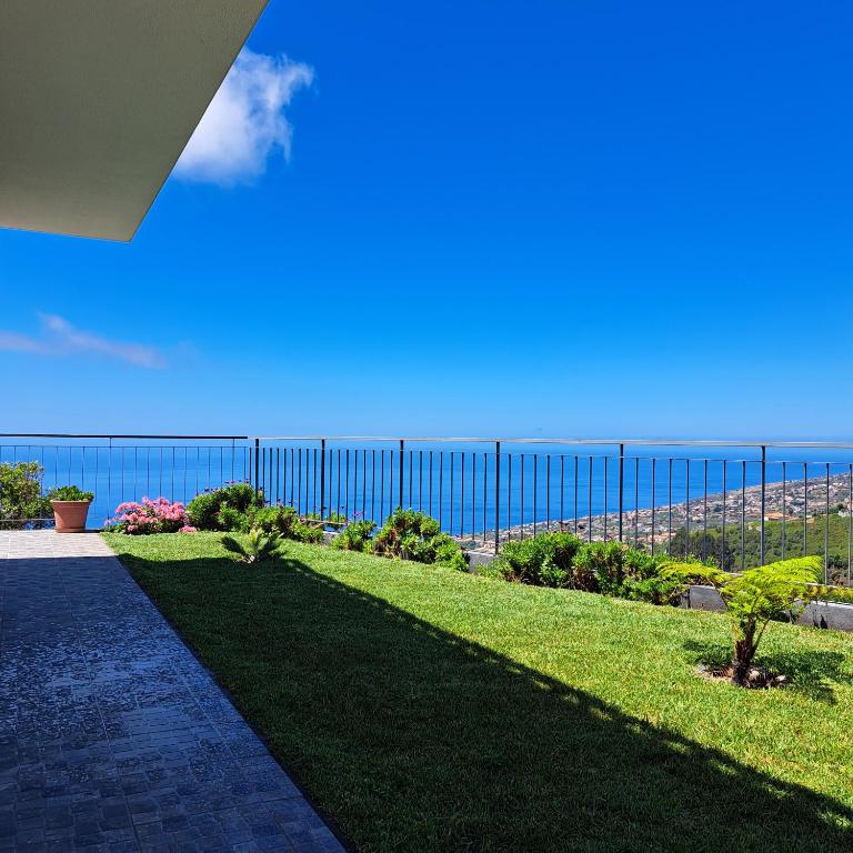 a fence with the ocean in the background at Hills and Atlantic Ocean retreat - Conceição House in Calheta