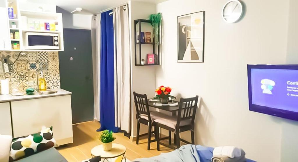 Il comprend un salon avec une petite table et une cuisine. dans l'établissement Private apartment in paris Defense, à Courbevoie