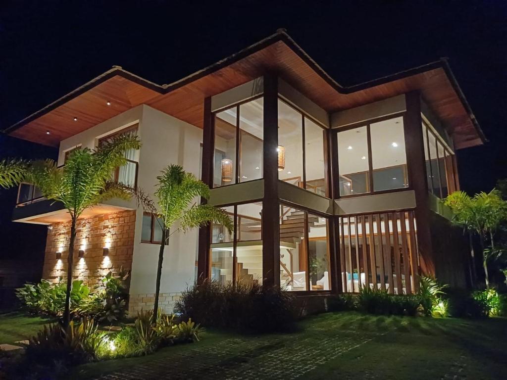 a large house at night with lights at Casa Malibu_Praia do Forte in Mata de Sao Joao