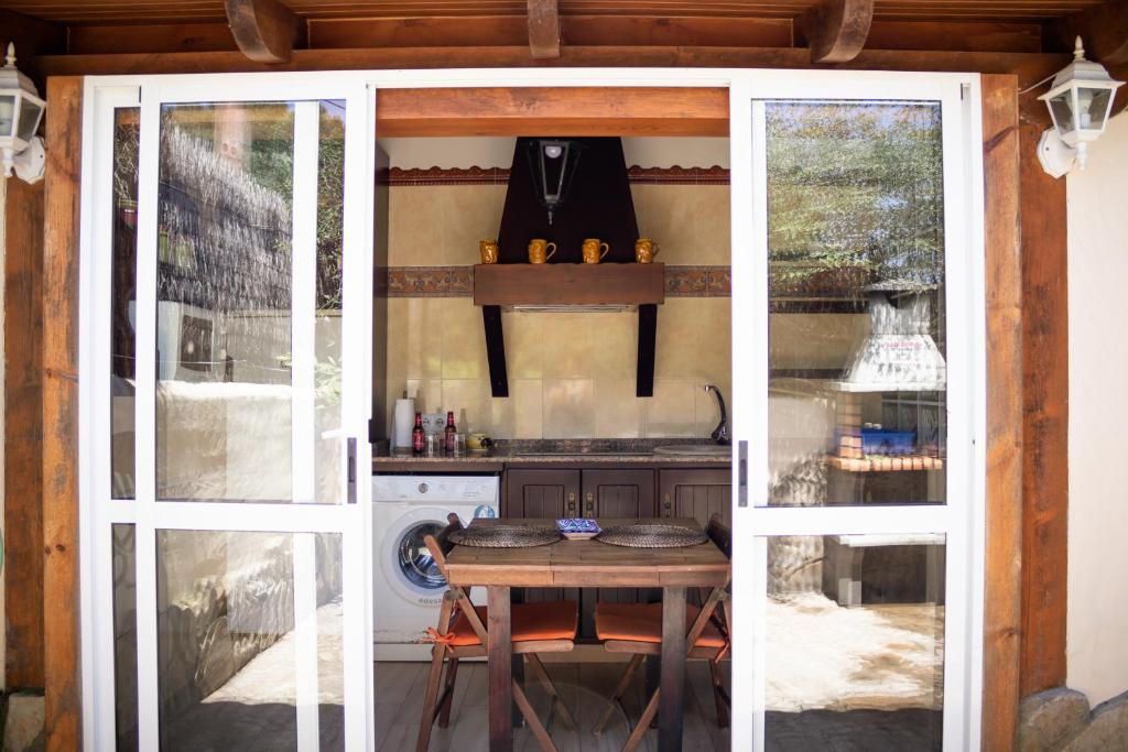 an open door to a kitchen with a table outside at Casas El Suspiro in Zahora