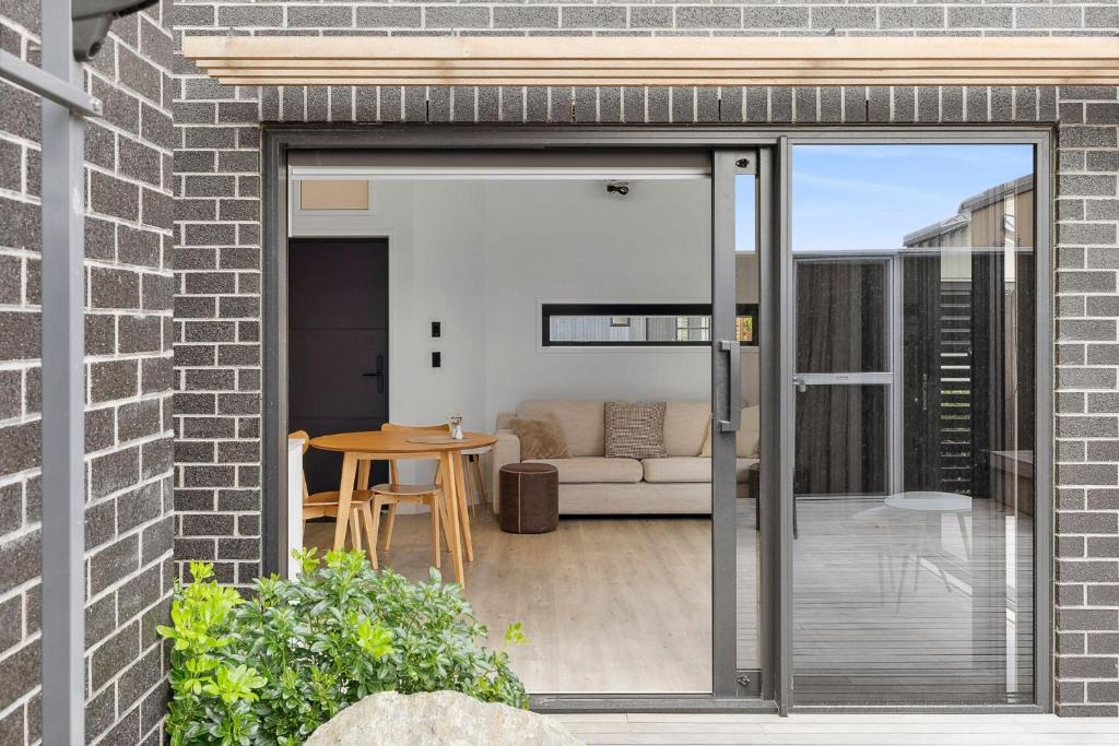 an open door to a patio with a couch at Boutique One Bedroom Haven in Wanaka