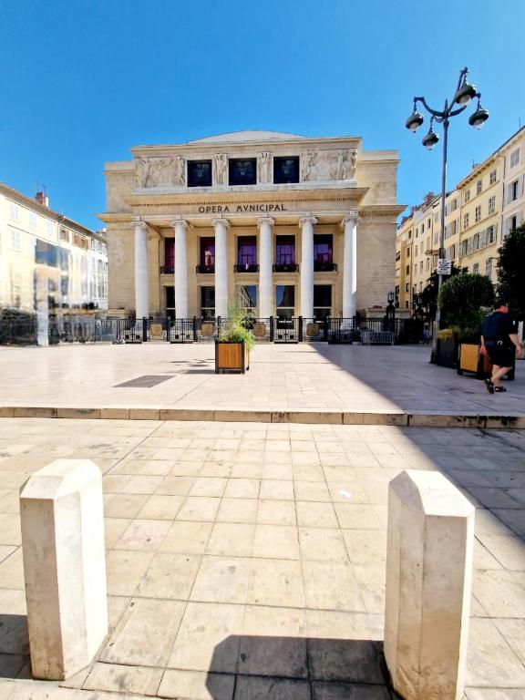 un grand bâtiment avec des piliers devant lui dans l'établissement Studios de Marseille - Vieux-Port - Quartier Opéra, à Marseille