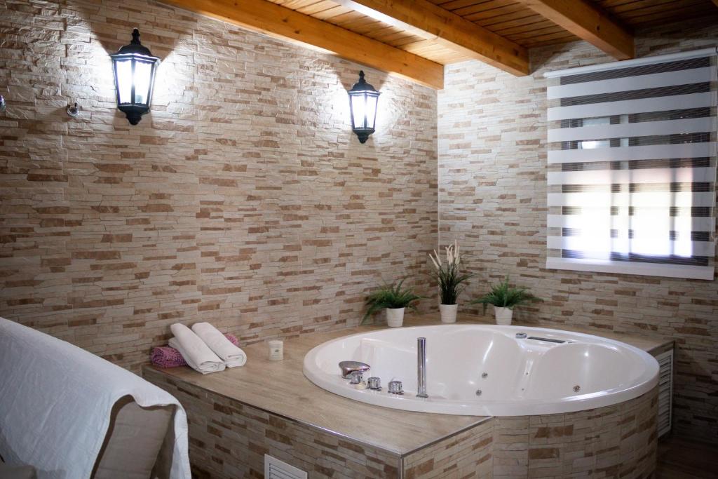 a large white tub in a bathroom with two lights at Casas El Suspiro in Zahora