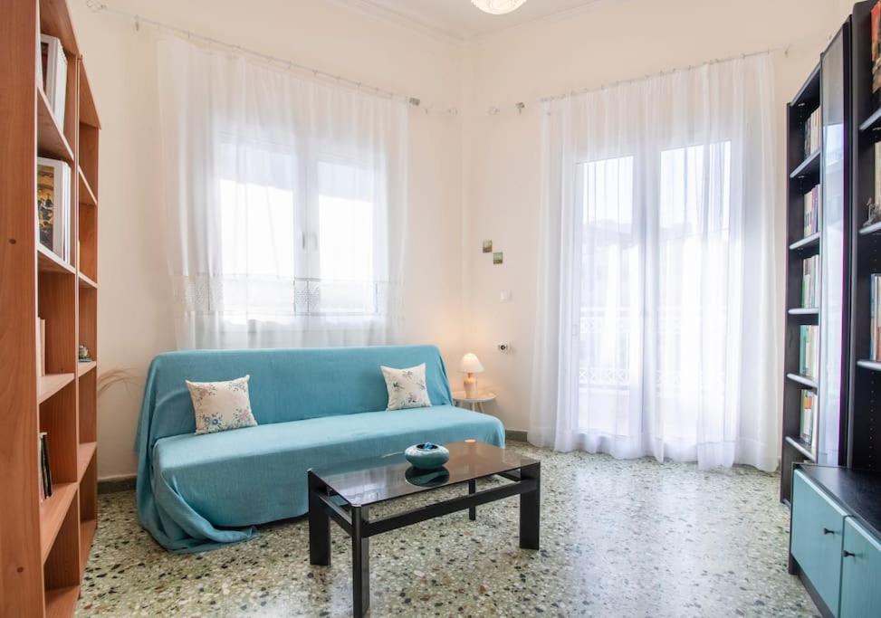 un salon avec un canapé bleu et une table dans l'établissement Vintage Charm Apt near Centre, à Héraklion