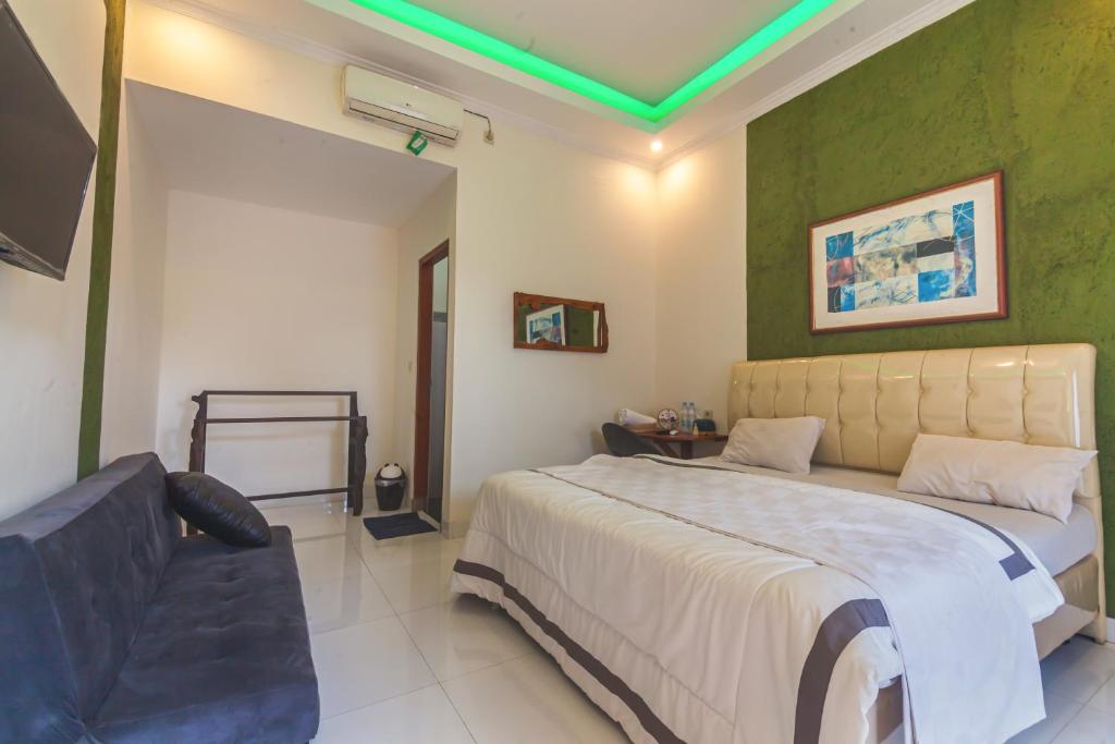 a bedroom with a large bed and a couch at Morobudur Homestay in Borobudur