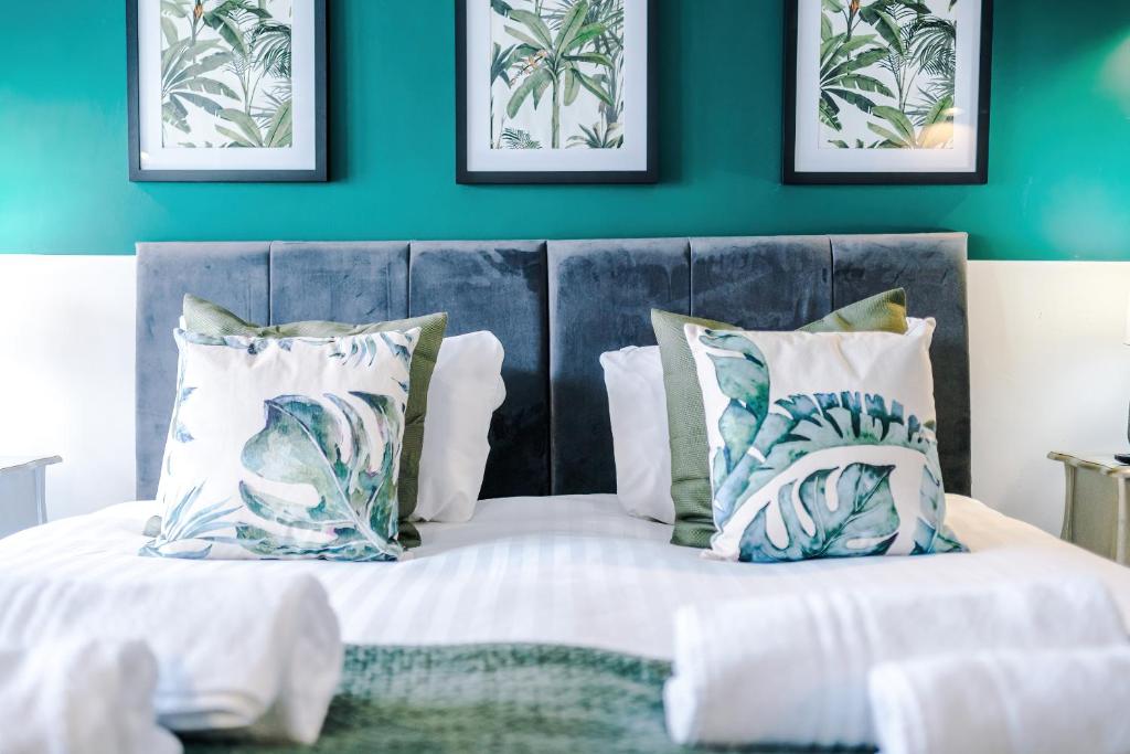 a bedroom with a blue wall and a bed with pillows at 'Apple Store' - Mochdre Cottages in Mochdre
