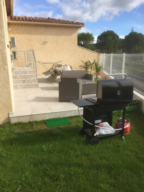 - une télévision sur une voiturette en gazon dans une cour dans l'établissement Ales Cevennes villa confort et tranquillité, à Saint Julien Les Rosiers