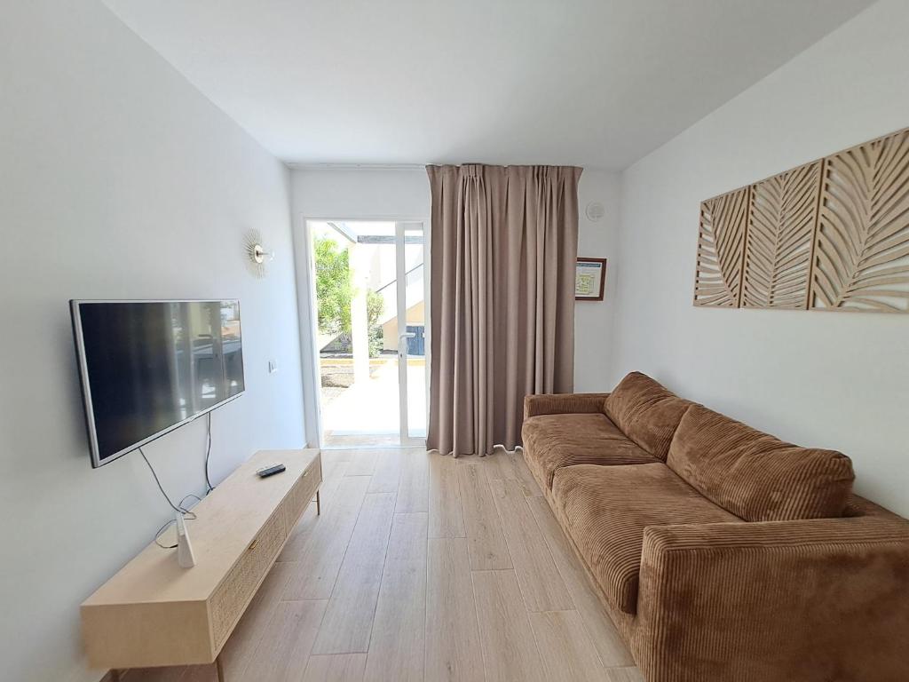 TV a/nebo společenská místnost v ubytování HomeForGuest Apartamento Alisios 1 con piscina en Corralejo
