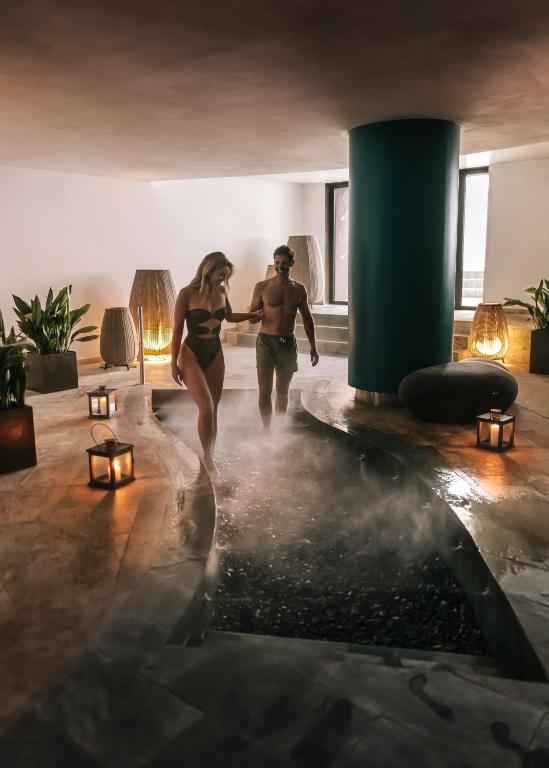 a man and woman running through a room with steam at Hard Rock Hotel Ibiza in Playa d'en Bossa