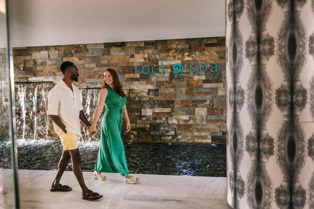 a man and a woman walking in front of a fountain at Hard Rock Hotel Ibiza in Playa d'en Bossa