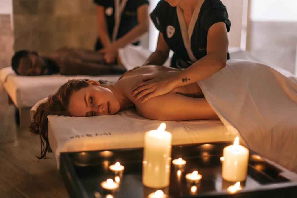 a woman laying on a bed in front of candles at Hard Rock Hotel Ibiza in Playa d'en Bossa