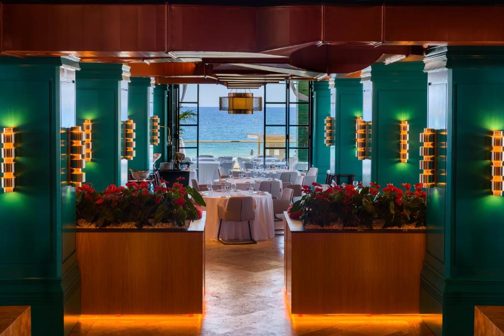a dining room with tables and flowers in a room at Hard Rock Hotel Ibiza in Playa d'en Bossa